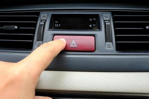 zeigefinger oder zeigefinger, der das rote not-aus-warnsicherheitskonzept des autos drückt foto