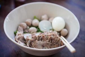 thailändische Nudeln mit Schweinefleisch und Schweinefleischbällchen in weißer Scheibe foto