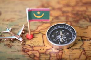 Flagge von Mauretanien, Kompass und Flugzeug auf der Weltkarte. foto