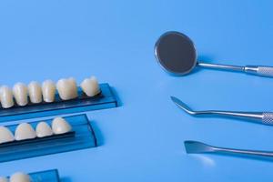 Zahnmodell mit zahnärztlichen Werkzeugen auf blauem Hintergrund foto