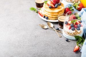 Frühstück mit Müsli, Pfannkuchen und Beeren foto