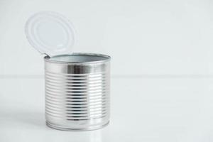 Eine offene Konservendose aus Aluminiummetall auf einem weißen Tisch. kopieren, leerer platz für text foto