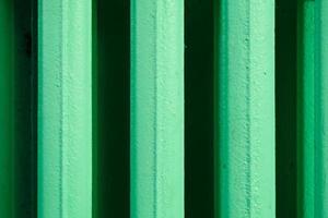 abstraktes vertikales Streifenmuster aus einer alten Heizbatterie aus Gusseisen und grün lackiert foto