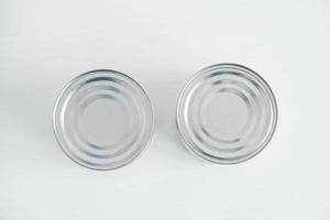 Zwei geschlossene Metalldosen aus Aluminium auf einem weißen Tisch. Ansicht von oben. kopieren, leerer platz für text foto