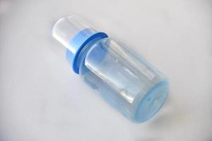 blaue Babyflasche mit einem Schnuller für Wasser foto