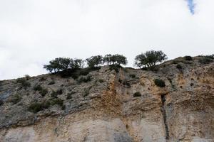 riesiger Felsen mit einigen Bäumen oben, von unten gesehen. san pantaleon de la losa, merindades burgos, spanien foto