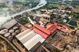 Zucker-Bioethanol-Übersetzungsfabrik, die mit Dampf aus dem Schornstein und dem Zuckerrohr-LKW arbeitet foto