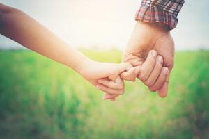 Nahaufnahme des Vaters, der seine Tochter an der Hand hält, so süß, Zeit mit der Familie. foto