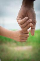 Nahaufnahme des Vaters, der seine Tochter an der Hand hält, so süß, Zeit mit der Familie. foto