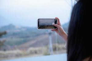 Frau mit Smartphone fotografiert in Khao Kho, Thailand foto