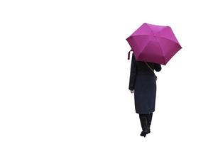 Ein Mädchen mit einem Regenschirm auf weißem Hintergrund steht mit dem Rücken. foto
