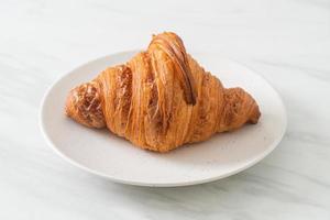 frisches Croissant auf weißer Platte foto