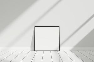 minimalistisches und sauberes quadratisches schwarzes plakat oder fotorahmenmodell auf dem boden, der sich mit schatten an die raumwand lehnt foto