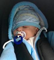 schlafendes Baby mit Kinderschnuller posiert Fotograf für Farbfoto foto