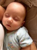 schlafendes Baby mit Kinderkleidung posiert Fotograf für Farbfoto foto