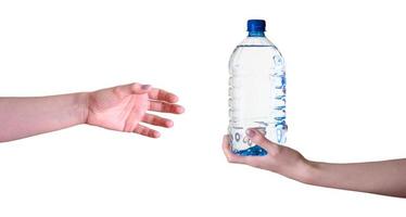 Die Hand einer Frau mit einer Flasche Wasser geht auf einem weißen Hintergrund in die andere Hand über. foto