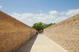 die Straße mit Ziegelmauern auf beiden Seiten. die alten gebäude des mittelalterlichen asiens foto