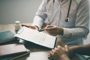 Der Arzt schreibt den Terminbrief an den Patienten in der Klinik. foto