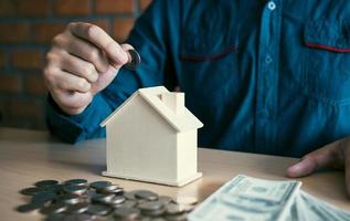 Männer stellen Münzen zusammen mit der Idee, Geld zu sammeln, um ein neues Haus zu kaufen. foto