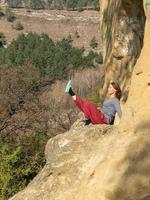 lächelnde frau mit geschlossenen augen, die auf einem berg sitzt und an einem herbsttag yoga navasana praktiziert foto