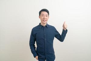 junger asiatischer mann daumen hoch oder ok handzeichen foto