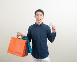 Porträt junger asiatischer Mann mit Kreditkarte und Einkaufstasche foto