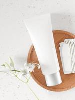 Ein Modell einer realistischen weißen leeren Kosmetiktube isoliert auf weißem Hintergrund mit Blume, 3D-Rendering, 3D-Illustration foto