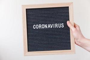 frauenhand, die schwarzes buchstabenbrett mit textphrase coronavirus hält. neuartiges Coronavirus 2019-ncov, Mers-cov-Coronavirus des Atemwegssyndroms im Nahen Osten mit Ursprung in Wuhan, China foto