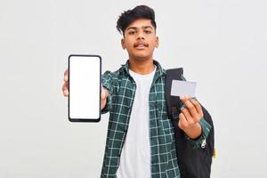 Indischer College-Student, der mobilen Bildschirm und Karte auf weißem Hintergrund zeigt. foto