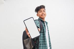 junger indischer College-Student, der Smartphone-Bildschirm auf weißem Hintergrund zeigt. foto
