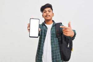 Indischer College-Student mit mobilem Bildschirm auf weißem Hintergrund.