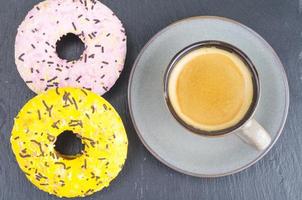 Tasse Espresso mit frischem Gebäck zum Frühstück auf schwarzem Steinhintergrund. foto