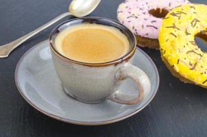 Tasse Espresso mit frischem Gebäck zum Frühstück auf schwarzem Steinhintergrund. foto