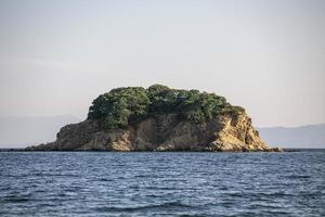 großer felsen im blauen wasser von paralia vasilias, skiathos, insel skiathos, griechenland. foto