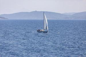 Ein einzelnes weißes Segelboot im offenen Meer. foto