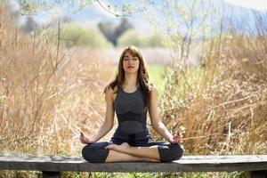 junge schöne Frau, die Yoga in der Natur macht foto