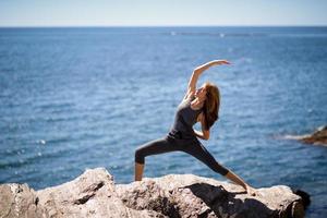 junge Frau beim Yoga am Strand foto