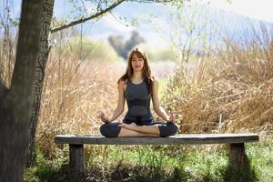 junge schöne Frau, die Yoga in der Natur macht foto