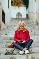 junge frau, die mit einer alten kamera in einer schönen stadt fotografiert. foto