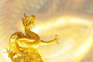 heiliger goldener drache, der auf goldenem undeutlichem texturhintergrund für chinesisches und östliches thema aufzieht foto