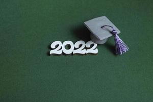 Abschlusskappe und Zahlen 2022 auf grünem Hintergrund, Nahaufnahme mit Kopierraum. Konzept der medizinischen Ausbildung. foto