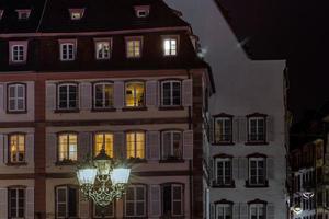 Straßenlaterne und Gebäude mit hervorgehobenen Fenstern, Nachtansicht von Straßburg foto