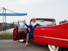 60er Jahre Oldtimer roter Cadillac und ein wunderschönes junges Mädchen foto