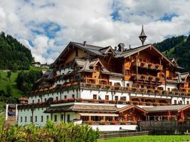 grüne hügel eines alpinen resorts in österreich im sommer. kleines Dorf, Hotels und Chalets, alles in Farben. schöne Terrassen und Sonnenkollektoren auf den Dächern. die Nähe von Zivilisation und Natur pur. foto