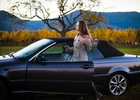 schönes Mädchen in einem Retro-Cabriolet, Abendlicht, Ruhe und Befriedung foto