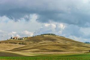 Villa in Italien, altes Bauernhaus in den Wellen der toskanischen Felder und Hügel foto