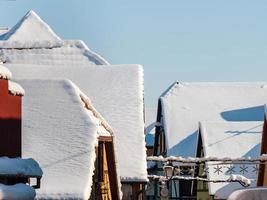 sonniger Wintertag. schneebedeckte Dächer von Häusern. Dorf im Elsass. foto