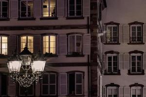 Straßenlaterne und Gebäude mit hervorgehobenen Fenstern, Nachtansicht von Straßburg foto
