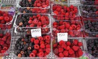 rote und schwarze Himbeeren in Plastikbehältern foto