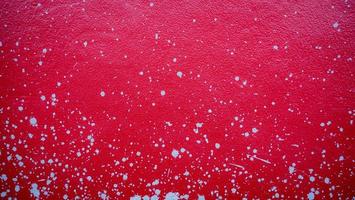 rote Zementwand mit Spritzspuren, verstreuter Mörtel, als Hintergrund oder Tapete verwendet.